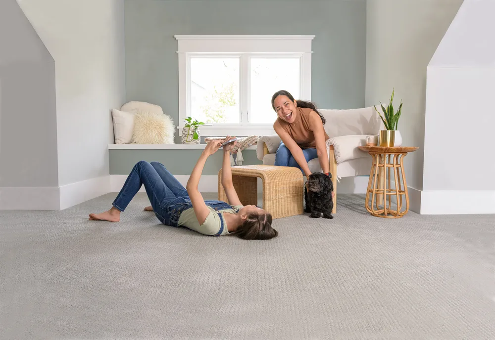 A mother and daughter relaxing with their dog on a freshly cleaned carpet