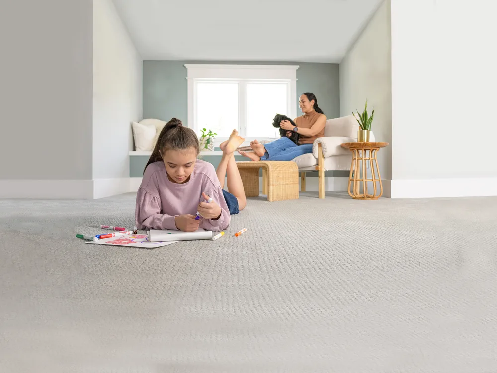 A child colouring on a freshly cleaned, dry carpet